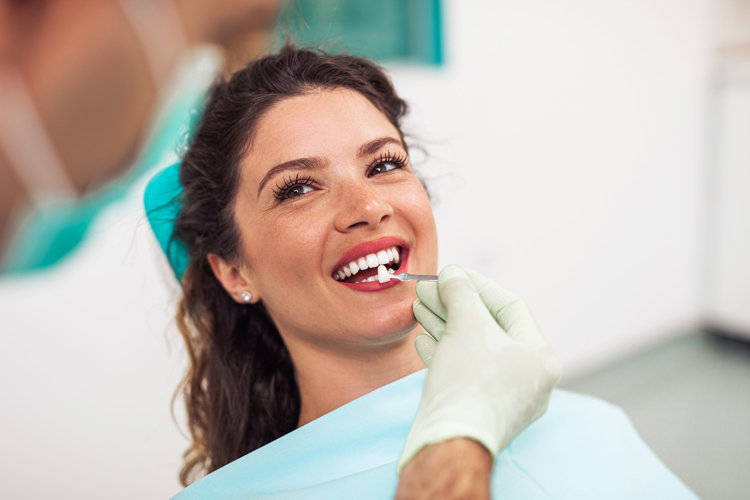 Beautiful woman sitting on dental chair and having dental treatment.