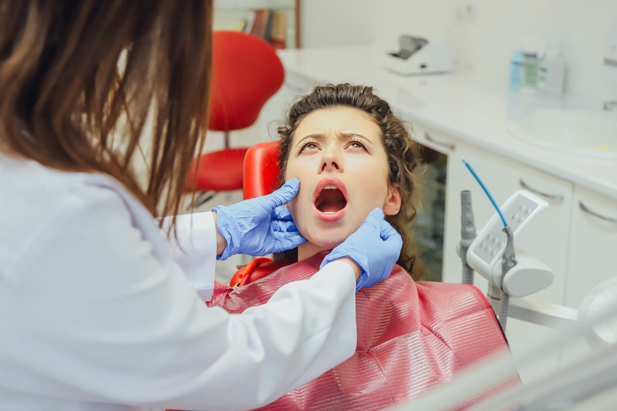 The girl is at the reception of a dentist. Happy client at the dentist smiles. Tooth whitening. Dental clinic. Dental treatment in a modern clinic. Recovery of healing