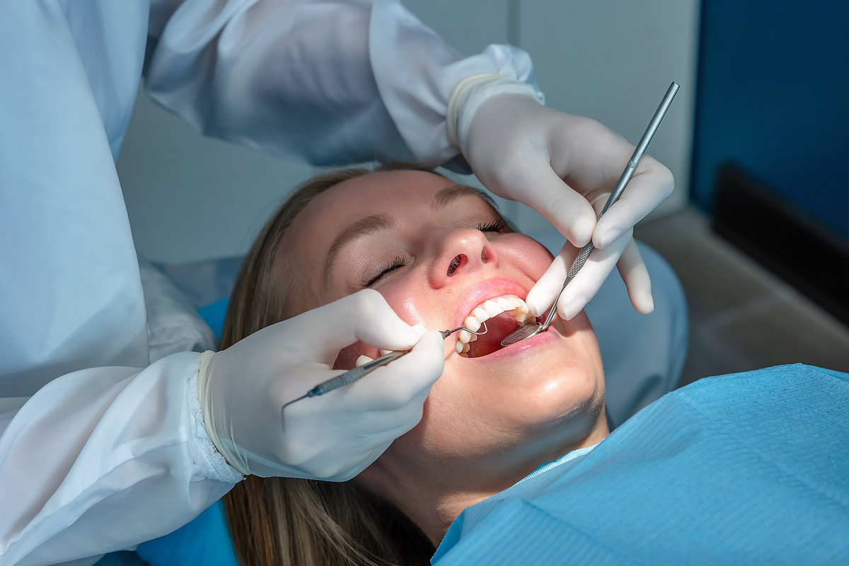 Dentist performing a routine dental checkup using mirror and probe. Professional oral examination in a modern dental clinic focused on preventive care and oral health.