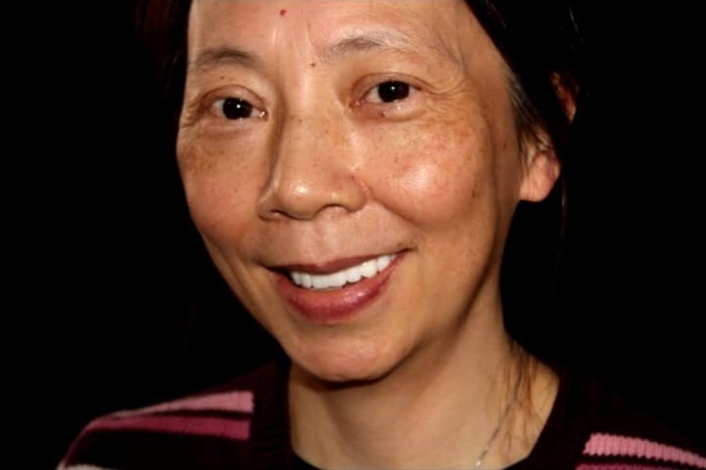 Woman with bright white smile after dental whitening at Evergreen Grace Dental Care