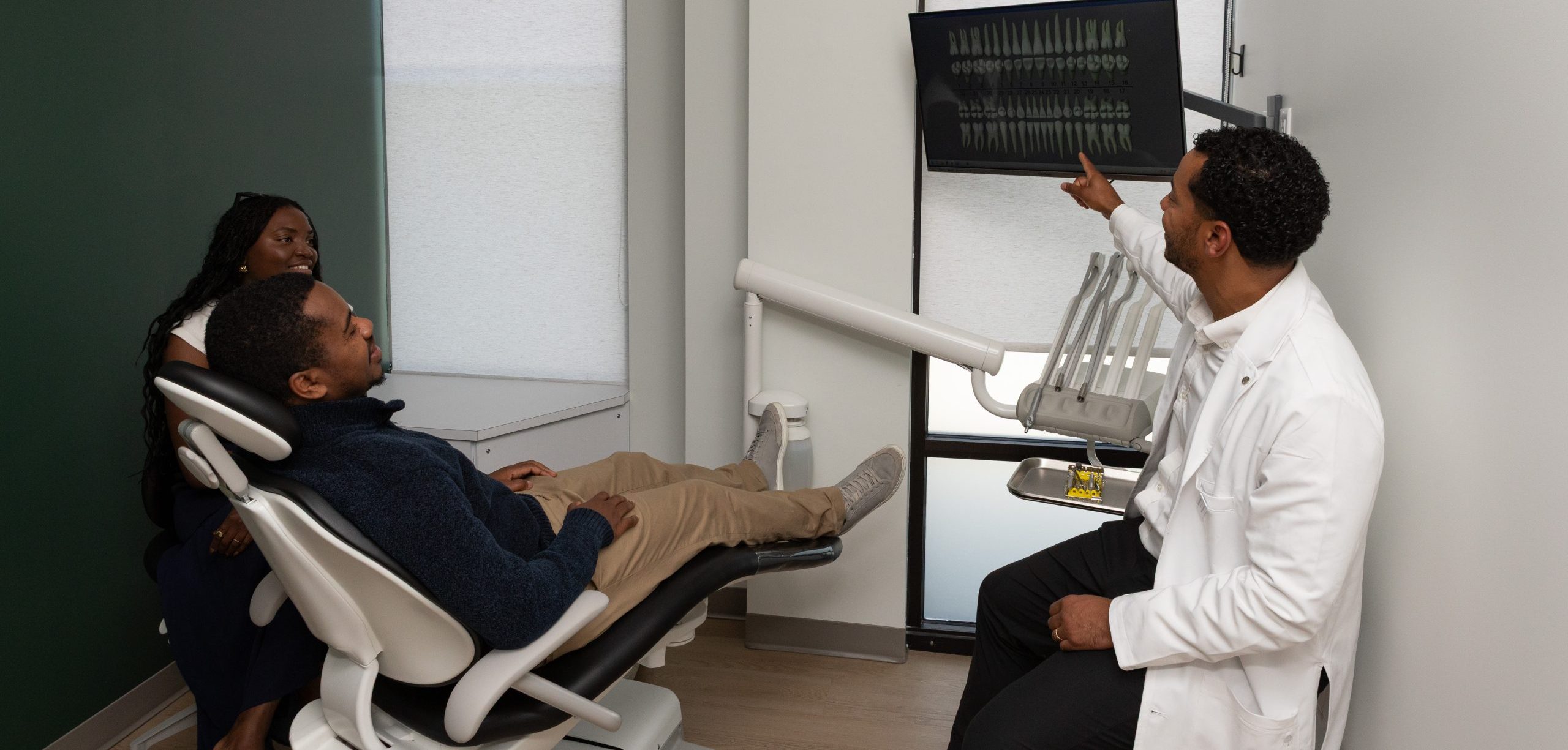 Evergreen Grace Dental Care dentist reviewing X-rays with patient and companion