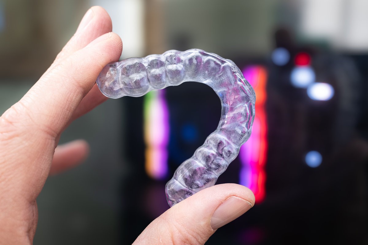 Transparent 3D Printed Mouthguard Held by Hand with Digital Dental Manufacturing Concept